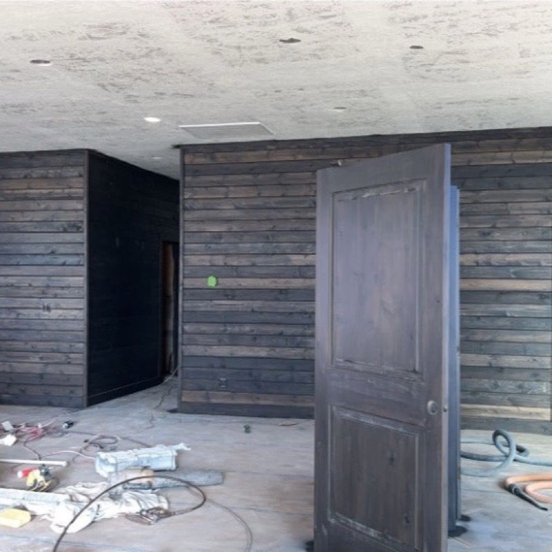 Modern interior with dark wood paneling and trim work in progress