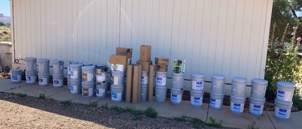 Professional paint and supplies staged on site for an exterior project